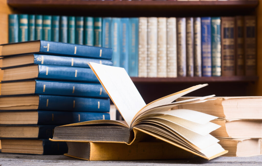 A stack of legal books outlining resources for prosecutors sits on a desk.